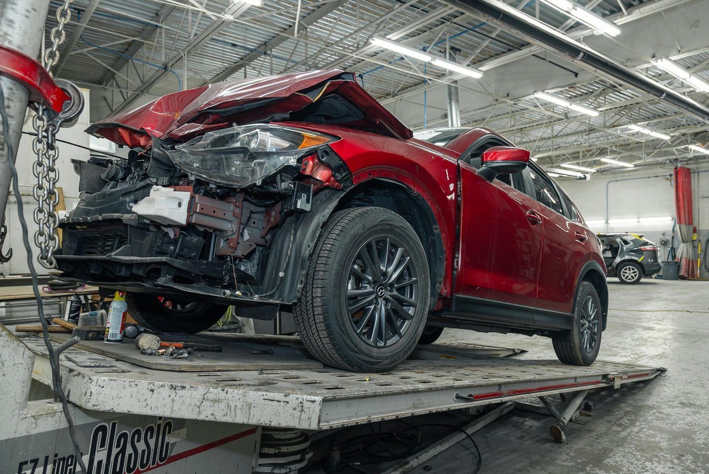 Damaged red car on a repair jig in the workshop